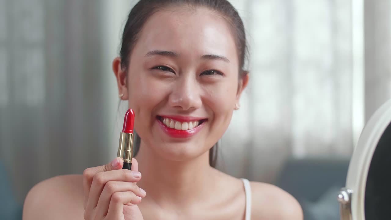 mujer aplicar lápiz labial rojo