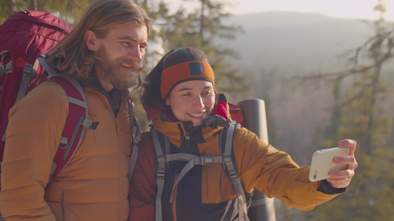 Couple Taking Selfie on Mountain Top during Winter Hike