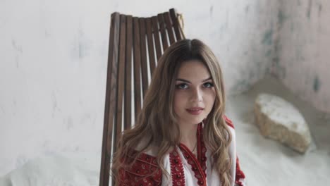 portrait-captures-a-beautiful-young-woman-in-an-embroidered-authentic-Ukrainian-shirt-posing-and-adjusting-her-hair-while-looking-into-the-camera