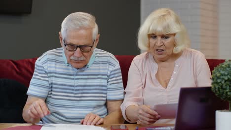 Senior-couple-checking-papers,-domestic-bills,-planning-budget-investment-loan-insurance-payment