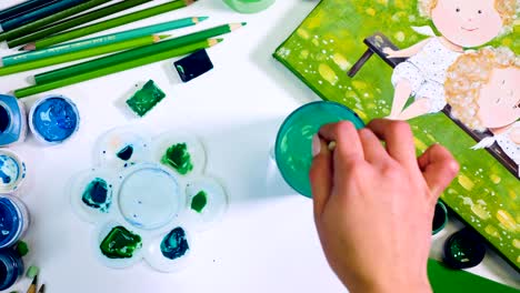 artist desk with abstract green items. artist choosing green shade. top view.