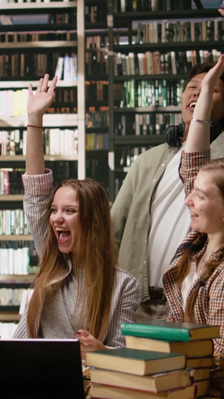 Vertical Video Students And Adult Learner Uniting Hands Over Library Table After Study Session