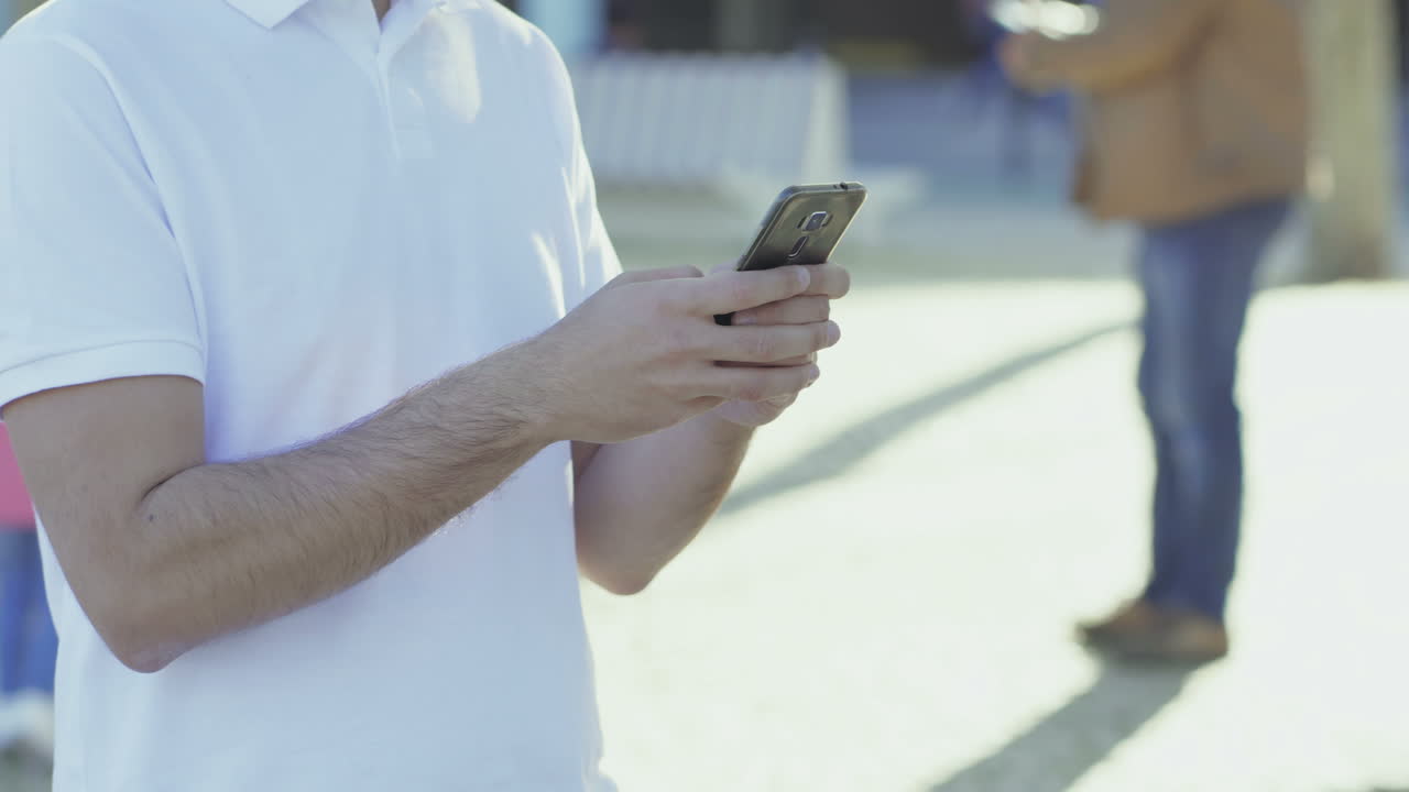 una foto recortada de un joven enviando mensajes de texto en su teléfono inteligente.