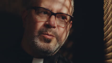 Close-Up of Priest Responding to Penitent in Confession
