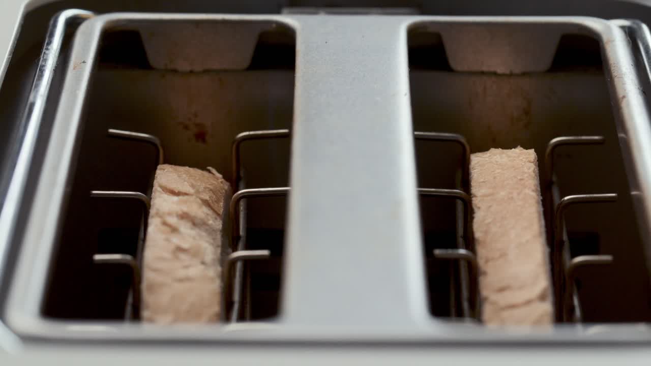 Close-Up of Crisping Bread Slices in Kitchen Toaster