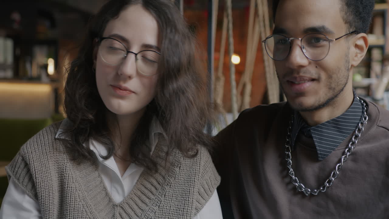 Two young adults in conversation at a cafe