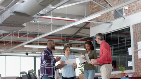 equipo de diversos colegas discutiendo mientras están juntos en la oficina