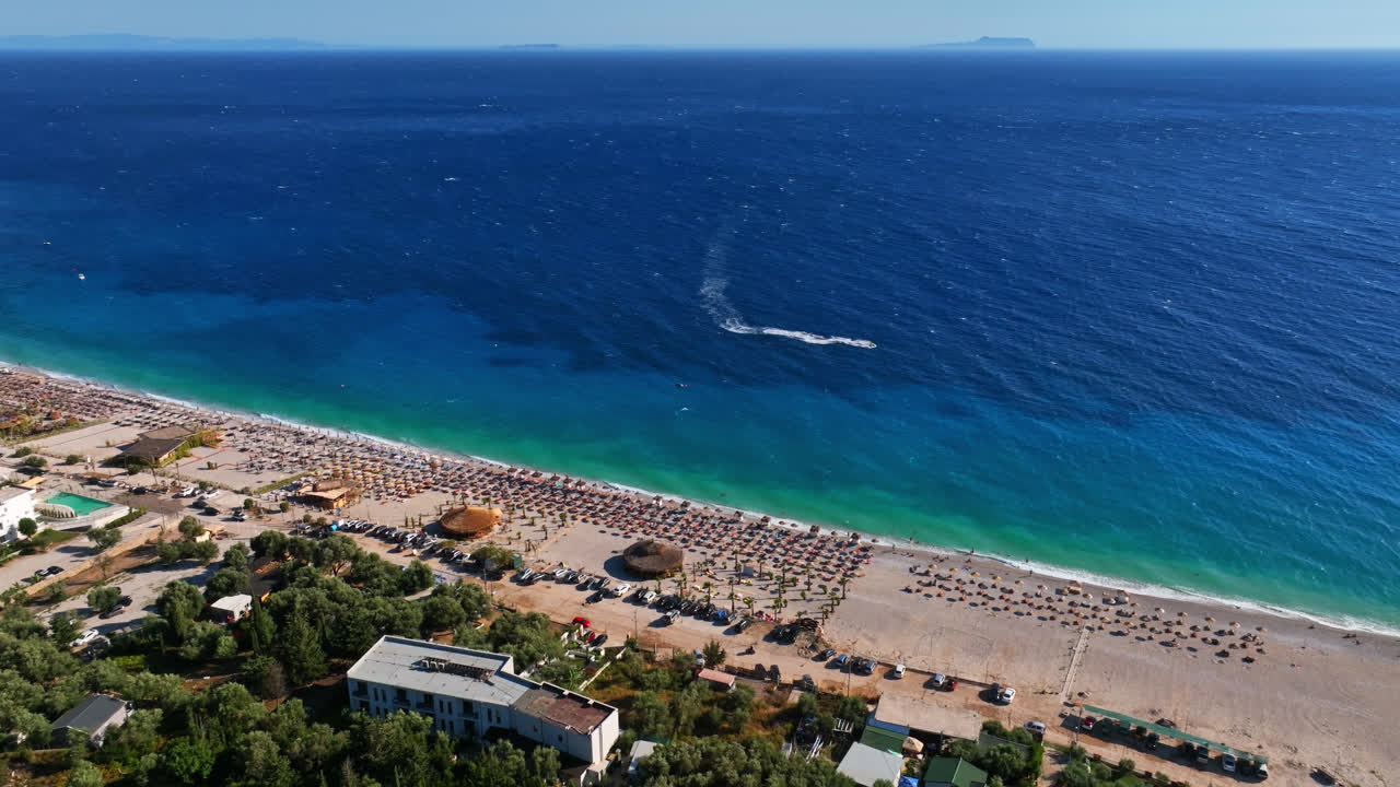 Aerial tracking shot of a boat on the Albanska riviera, sunny Dhermi, Albania