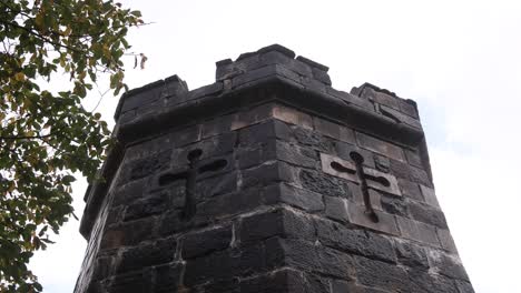 medieval-castle-pillar-with-gothic-cross-above-the-town-of-portree-on-Isle-of-Skye,-hIghlands-of-Scotland