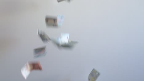 euro bills falling in slow motion on a white background