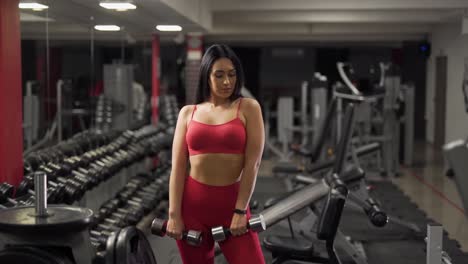 sexy girl with dumbbells posing in front of the camera and smiling