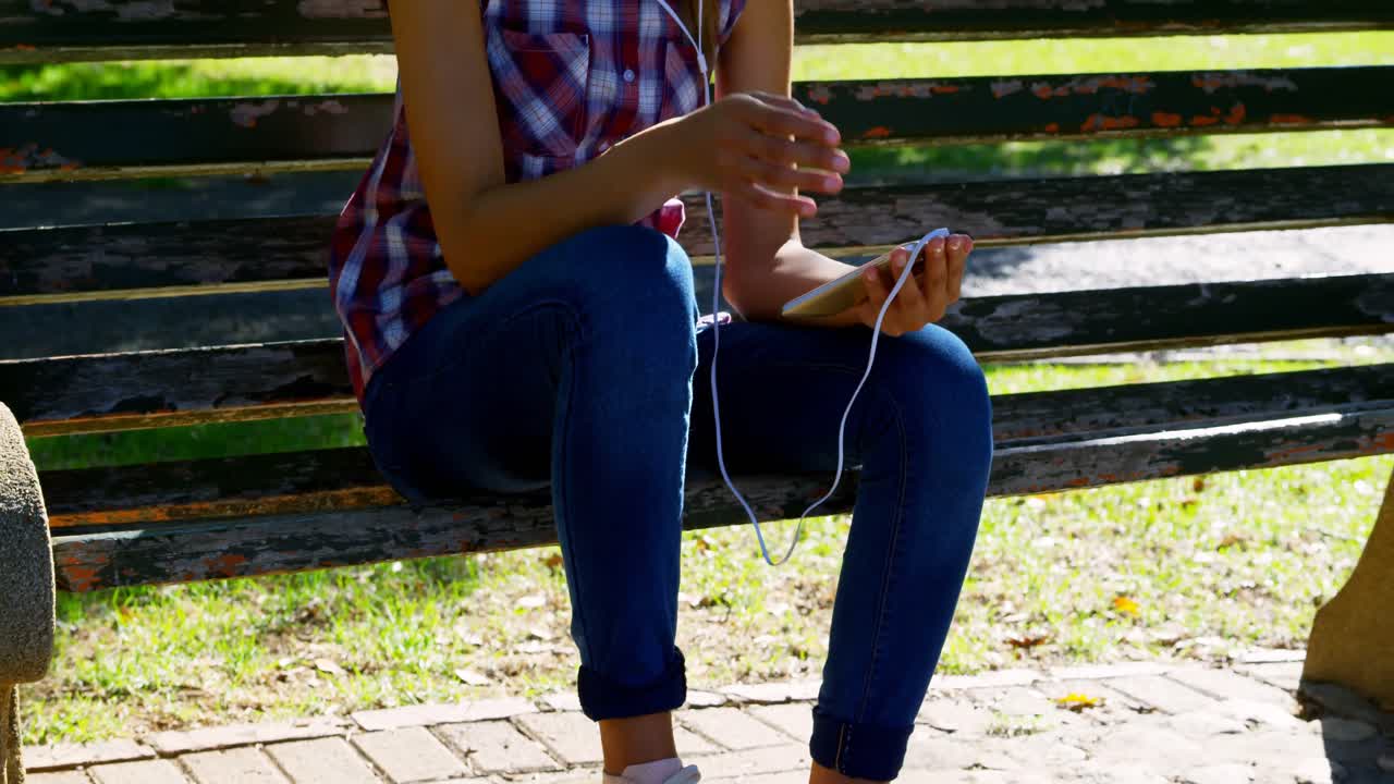 Woman listening music in park 4k