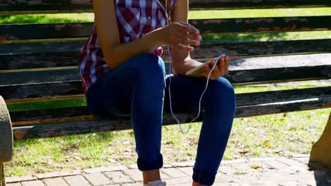 Woman-listening-music-in-park-4k