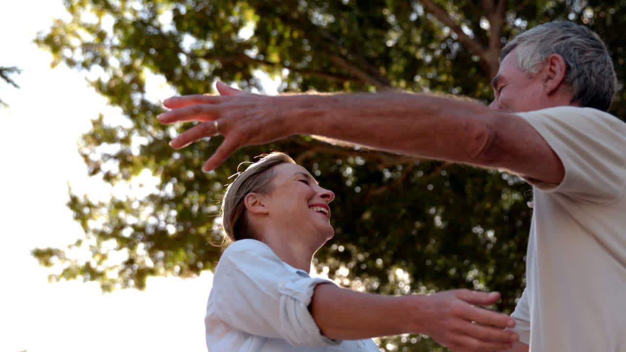 una pareja de mayores abrazándose en un día soleado.