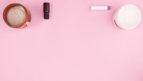 produtos de cuidados com a pele aparecem em tema rosa pastel. parar de movimento