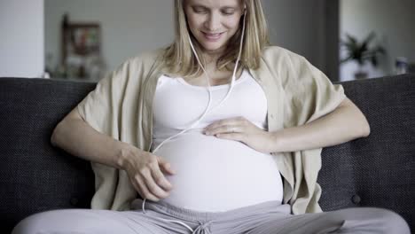 calm expectant mother sitting on sofa at home and relaxing