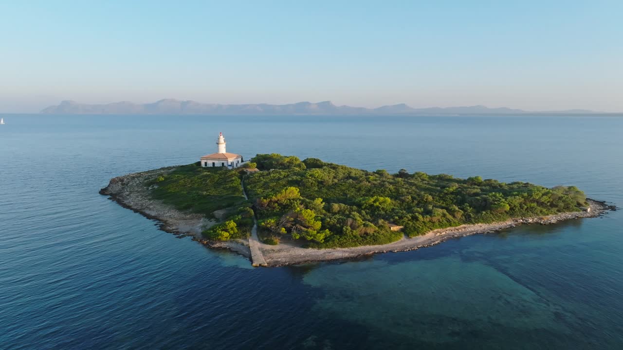 섬의 활기찬 초록색 나무와 열린 바다의 알카나다 등대