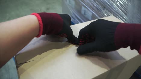 worker handling cardboard box with gloves