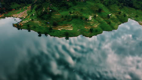 Tranquil-Lake,-Reflecting-Clouds-and-Lush-Agricultural-Land-in-Begnas-Lake,-Pokhara