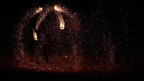 un artista muestra el arte del fuego en una playa.