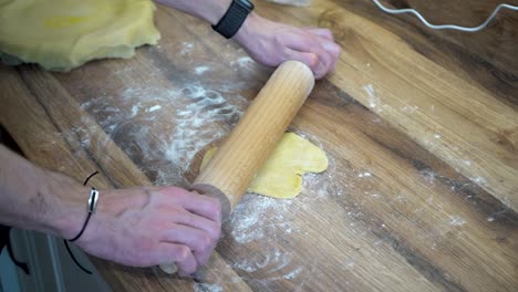 Mano-Del-Hombre-Estirando,-Masa-Rodante-Con-Rodillo-En-Un-Mostrador-De-Cocina