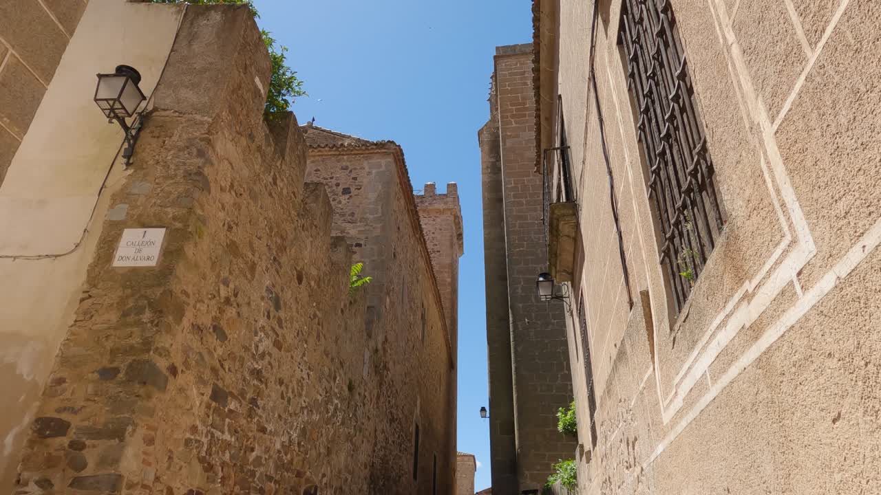 POV che guarda lungo un vicolo del centro storico di Cáceres, architettura gotica e rinascimentale e strade medievali acciottolate