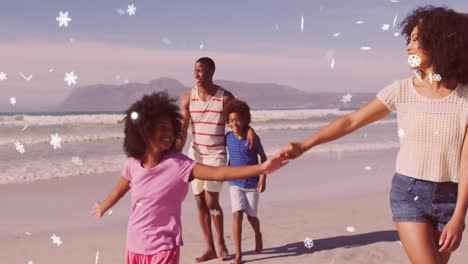 animation of christmas snow falling over biracial couple with son and daughter on beach