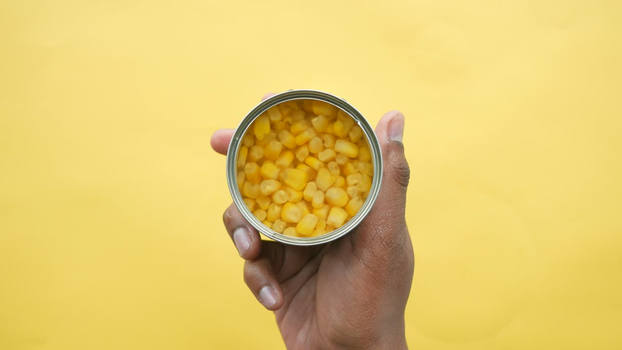 maíz enlatado en la mano