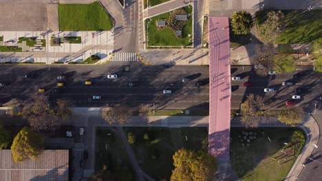 aerial top down view of busy highway underneath overhead pedestrian bridge crossing