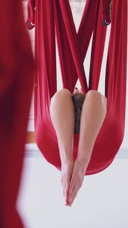 tired and relaxed ladies lie in fly yoga hammocks improving psychological and spiritual health close view