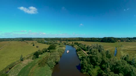 Imágenes-Aéreas-De-Drones-De-Un-Barco-A-Lo-Largo-Del-Río-Waveney,-Norfolk