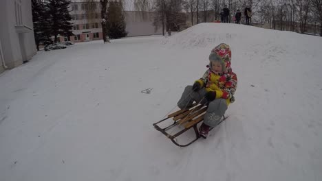 lady child slide down icy hill on toboggan in winter vacations