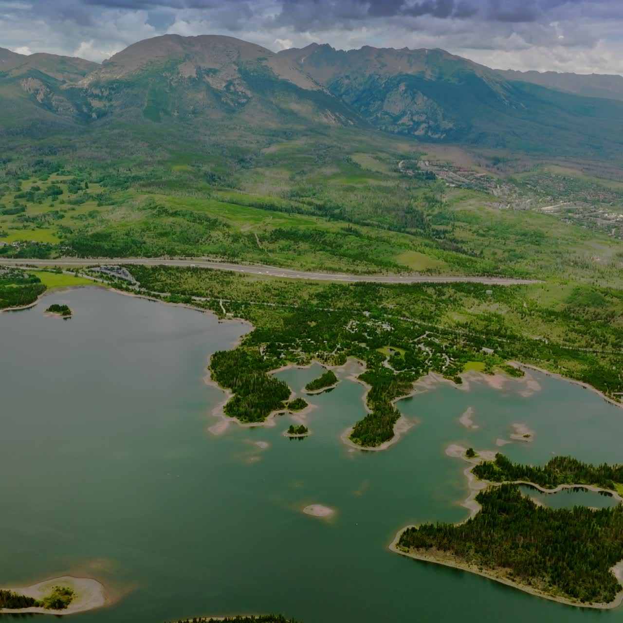 Beautiful scenery of river with little green islands in it. Gorgeous mountains of Colorado state. Aerial perspective