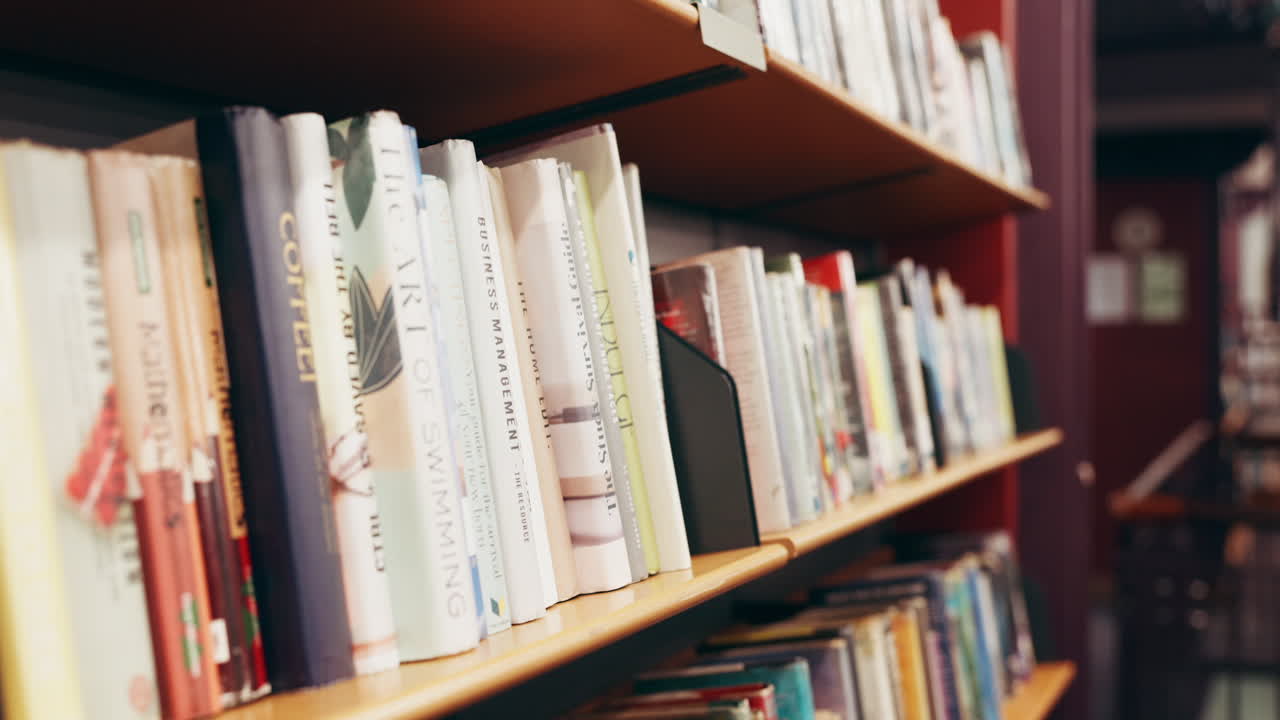 Eine Person, die ein Buch aus einem Bücherregal in einer Bibliothek auswählt