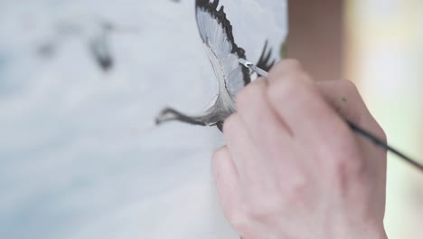 Close-up-scene-of-a-painter-who-is-painting-a-picture-on-an-easel