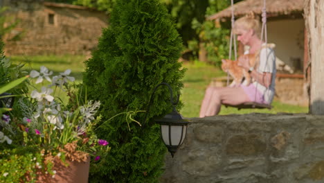 woman on tree swing strokes her adorable ginger pussy cat