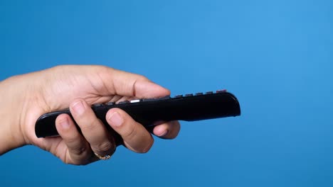 hand holding a black tv remote control