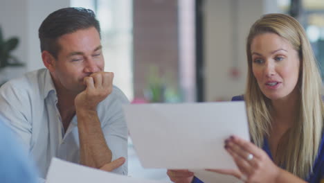 close up of business team having meeting sitting around table in modern open plan office