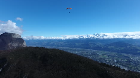 paraglider with snowy mountains in background. aerial view grenoble france