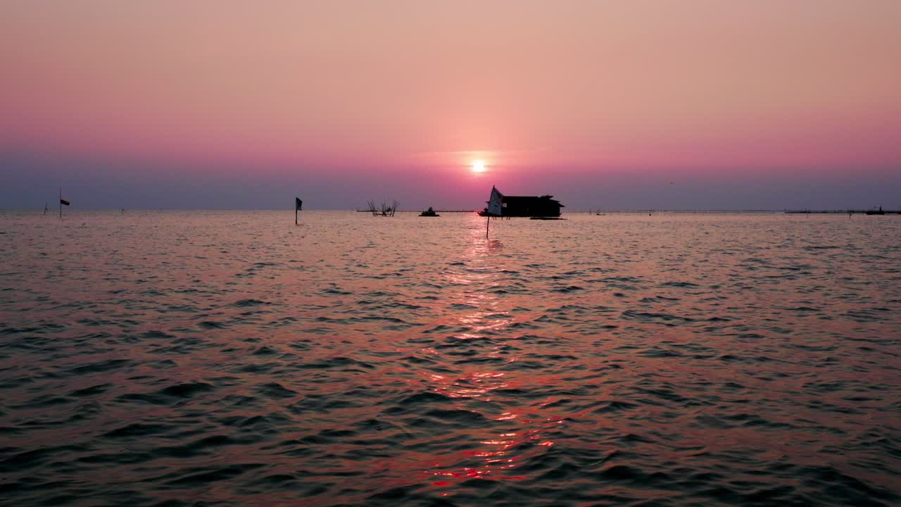 사프 톤, 아시아의 가장 큰 호수 마법의 반사 오렌지 해가 지평선에 집 보트와 함께