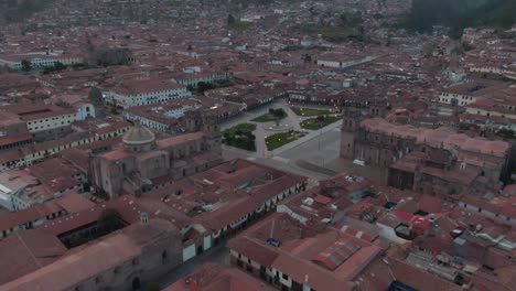 4K-aerial-drone-view-at-sunset-over-the-city-centre-in-Cusco-city,-capital-of-the-Incas