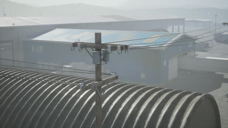 power lines and a warehouse in a foggy rural setting