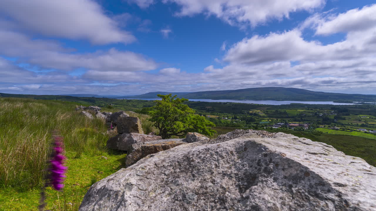 Time lapse of rural landscape with a single massive boulder rock in grassland hillside on a spring sunny day in Arigna mountains in county Leitrim in Ireland