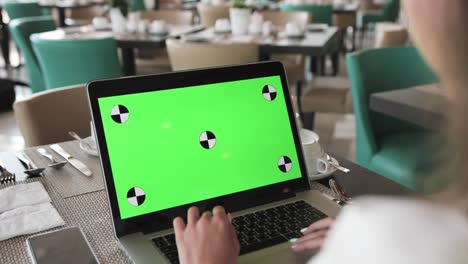 mujer trabajando en una computadora portátil en un café
