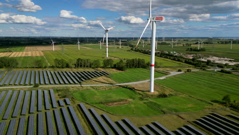 windturbines are spinning in a solar farm on a green field