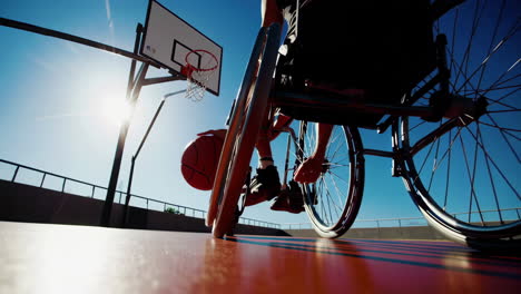 dynamic shot of wheelchair basketball player dribbling on an outdoor court