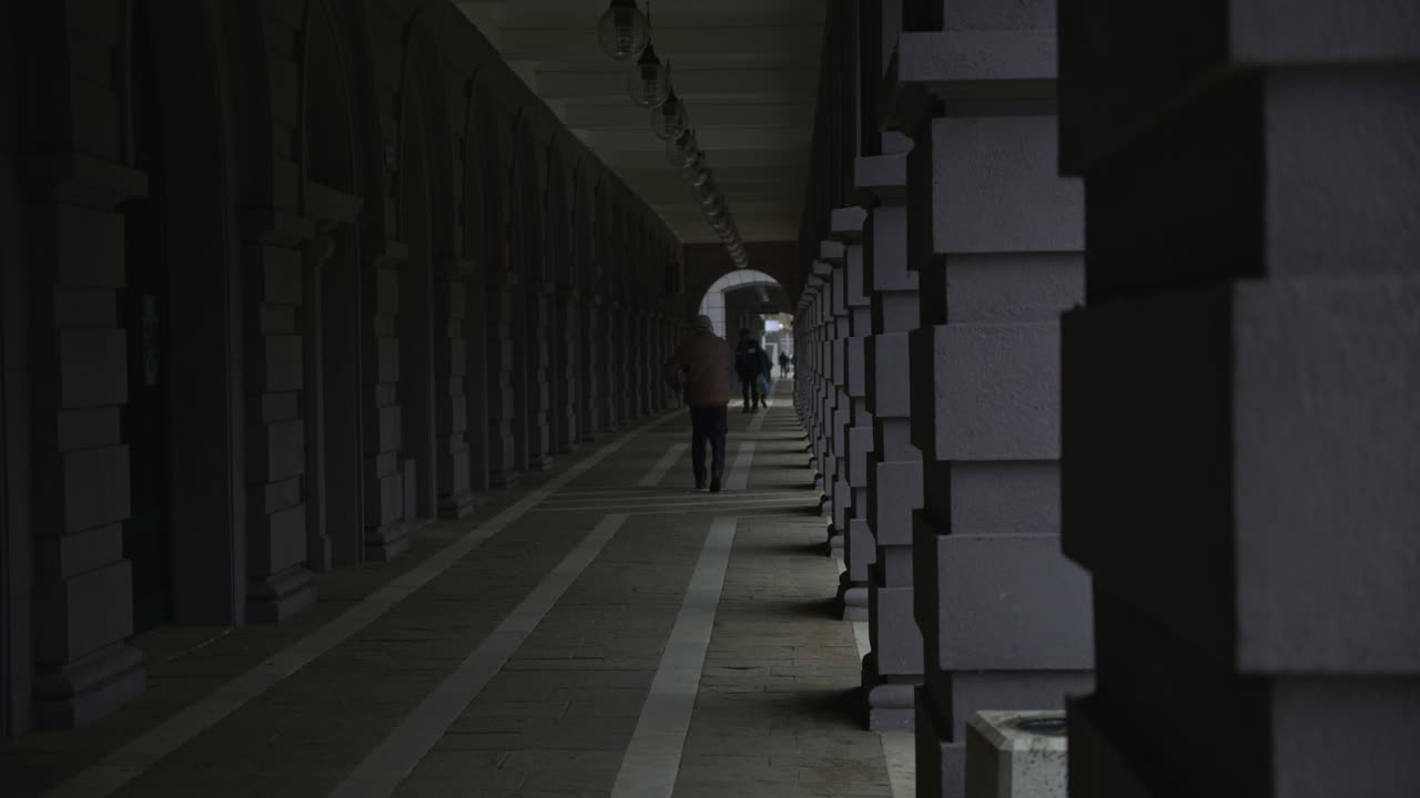 불가리아 디미트로브그라드 중심에서 아침 첫 시간 동안 골목을 걷고 있는 노인