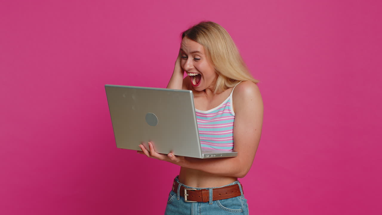 joven feliz trabajando en una computadora portátil ganando un juego de lotería en línea celebrando el éxito victoria