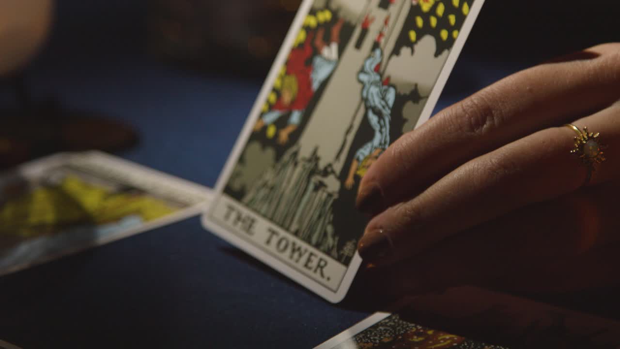 Close Up Of Woman Giving Tarot Card Reading On Candlelit Table Holding The Tower Card 2