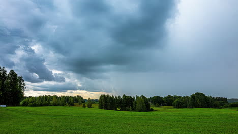 dark, stormy rainclouds blow in over the countryside landscape - dramatic time lapse cloudscape